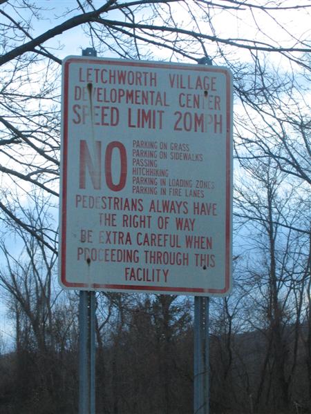 Letchworth Village Developmental Center; Speed Limit 20 mph; NO: Parking on grass, parking on sidewalks, passing, hitchhiking, parking in loading zones, parking in fire lanes; Pedestrians always have the right of way; Be extra careful when proceeding through this facility