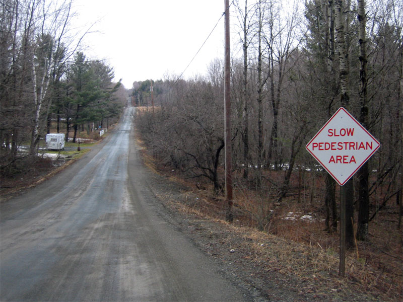 Slow pedestrian area (red text on white sign)